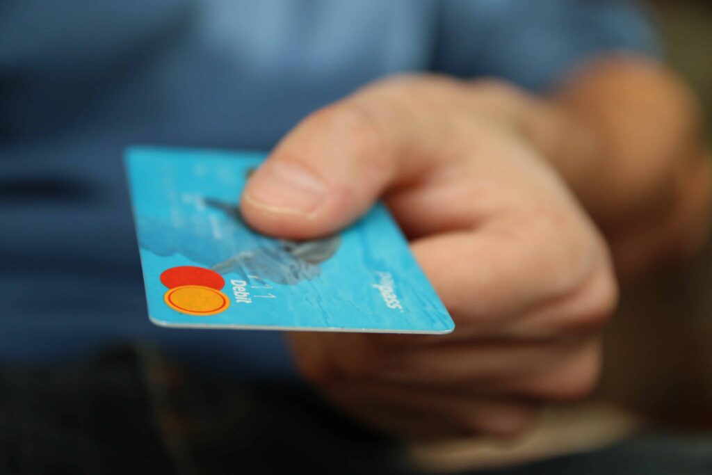 Hand holding a credit card, representing financial transactions and the importance of a bank business continuity plan.