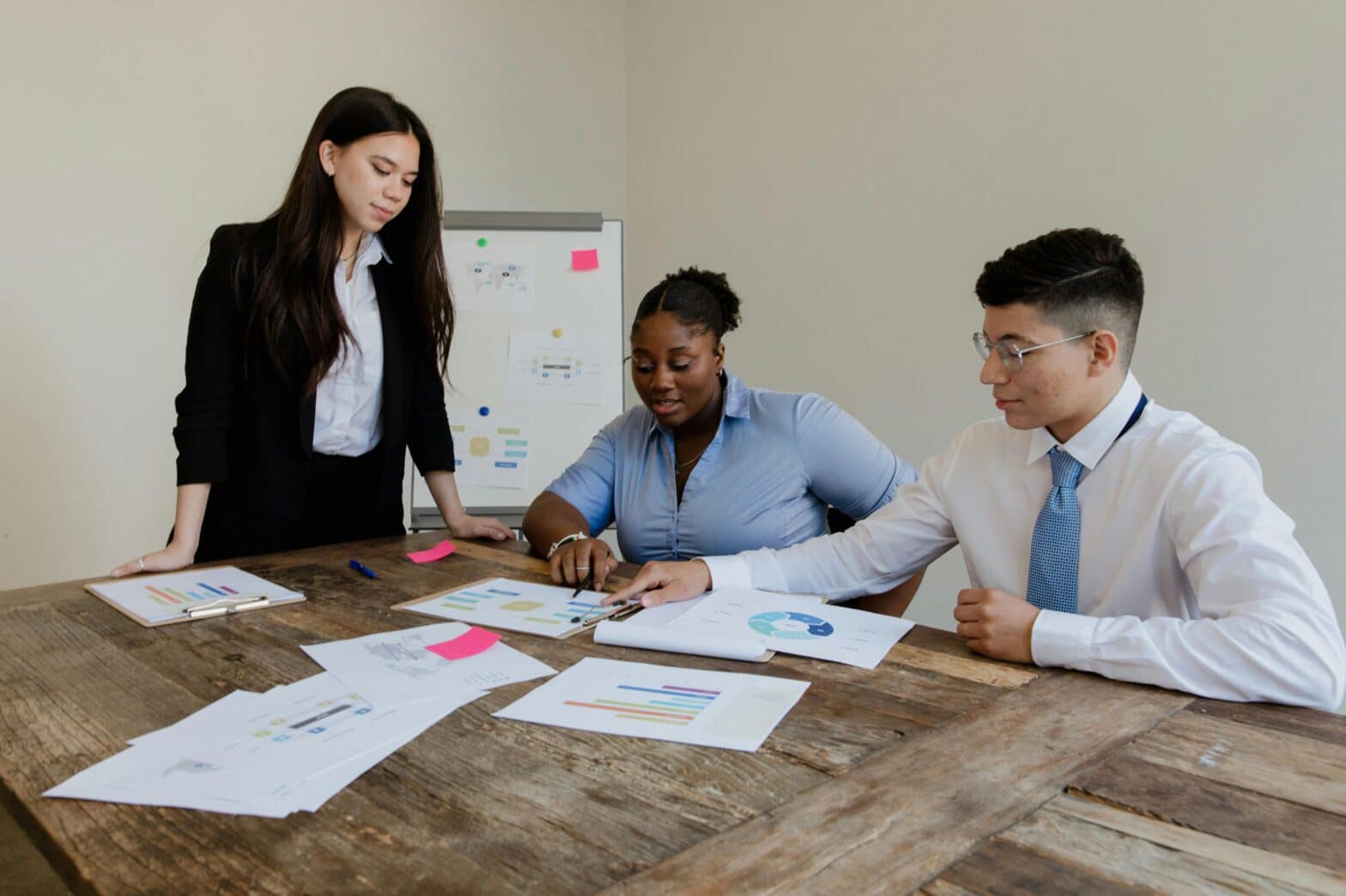 Group of professionals gathered around a table, engaged in discussions and activities related to business continuity plan testing scenarios and tabletop exercises.