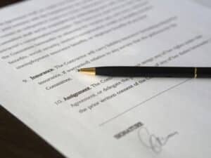 Close-up of a business cyber insurance policy document on a desk, highlighting coverage details for ransomware, data breaches, and business interruption, illustrating cybersecurity risk protection for companies.