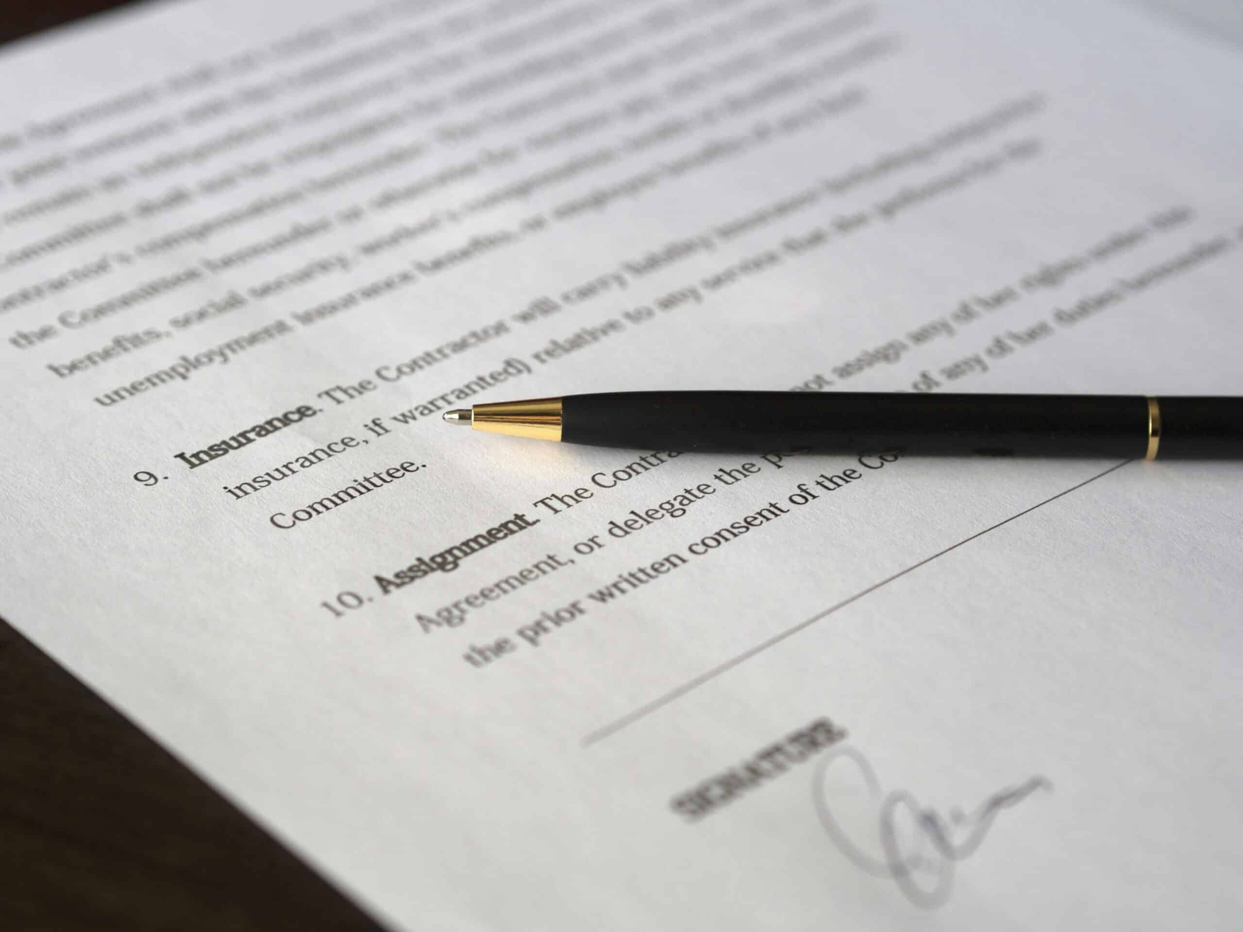 Close-up of a business cyber insurance policy document on a desk, highlighting coverage details for ransomware, data breaches, and business interruption, illustrating cybersecurity risk protection for companies.