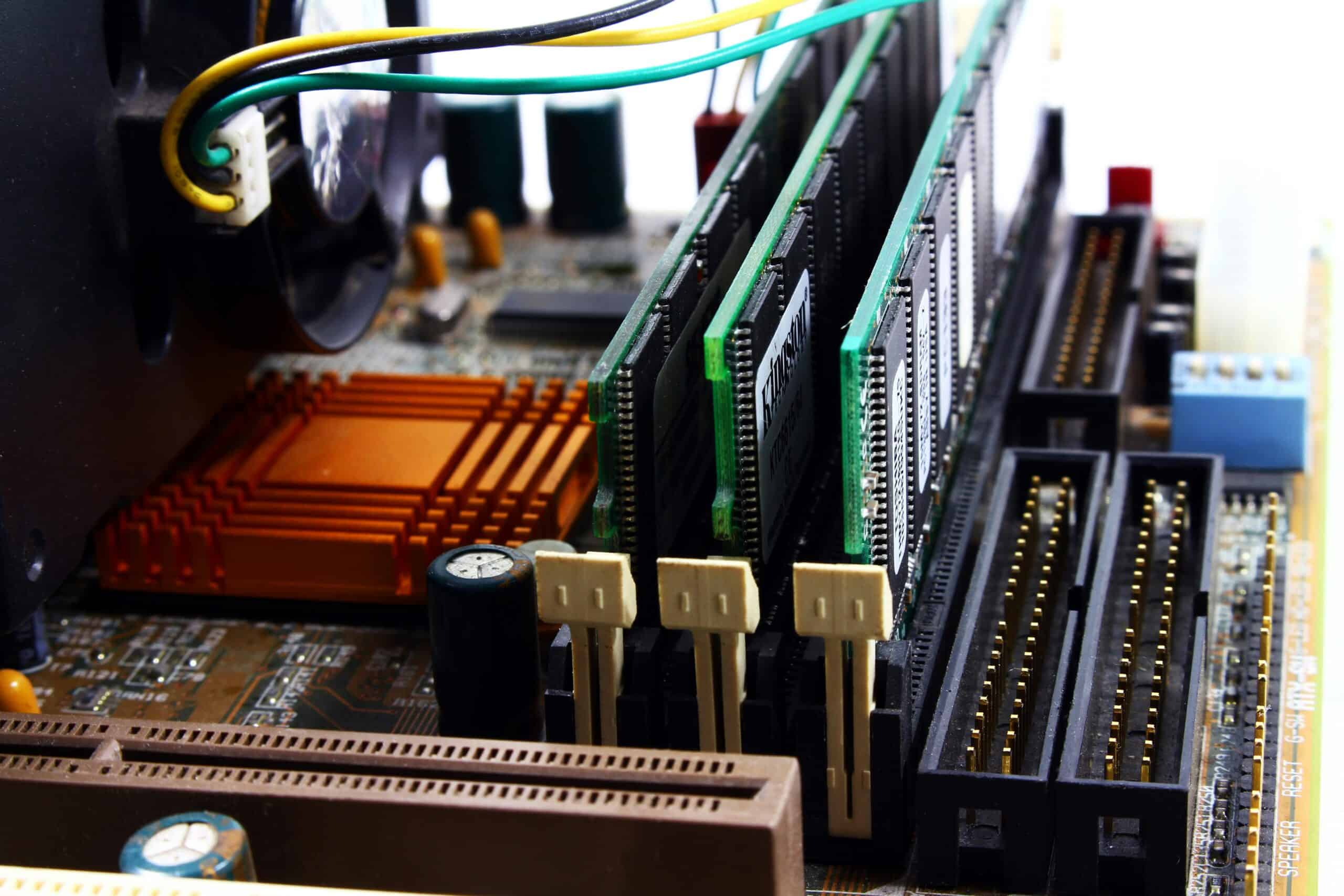Close-up of computer hardware components with cables and circuit boards, illustrating best practices to prevent data loss from hardware failure.